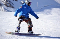 Ragazzo con protesi alla gamba fa snowboard sulla neve
