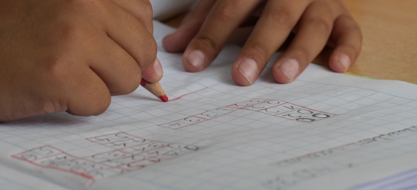 Mani di bambino che eseguono dei compiti di matematica elementari