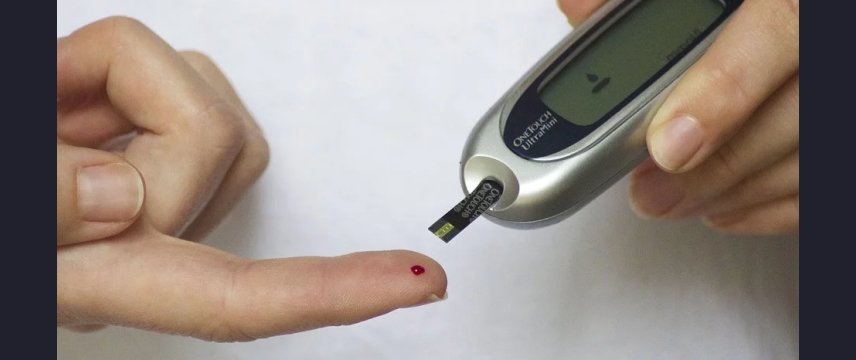 dettaglio delle mani di una persona che misura la glicemia nel sangue