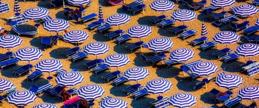 spiaggia con ombrelloni bianchi e blu