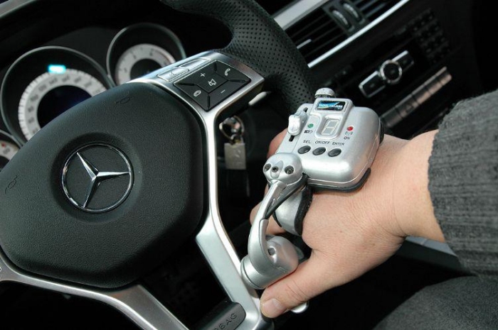 comando di guida al volante applicato a una mano