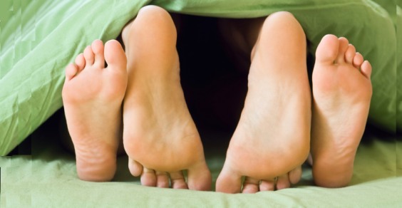 piedi di una coppia spuntano da sotto le coperte