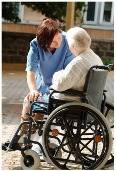 assistenza: una donna in sedia a rotelle vicino a una infermiera