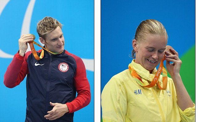 atleti accostano la medaglia all'orecchio