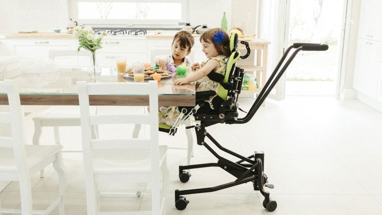 due bambini al tavolo della cucina, uno dei quali seduto sul SISTEMA POSTURALE TALLY