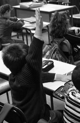 bambino in classe alza la mano per rispondere 