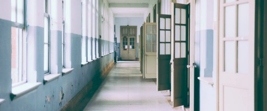 un corridoio scolastico vuoto con le porte aperte delle aule