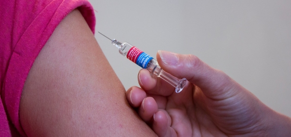 persona con camice da medico effettua un vaccino
