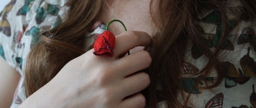 dettaglio di un fiore appassito in mano ad una donna