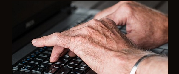 mani con artrite su tastiera di computer