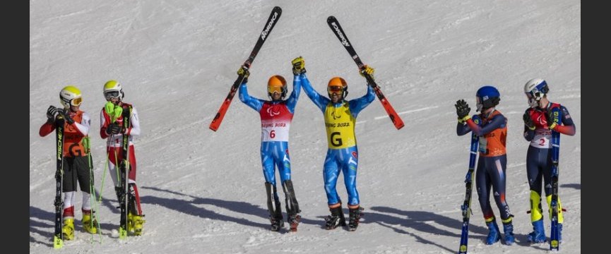 Bertagnolli e Ravelli esultano con gli sci in mano vicino a due altre coppie di sciatori