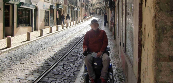 Mirko Ferranti, seduto sulla sua carrozzina elettrica sulla strada che porta al Castelo di Lisbona