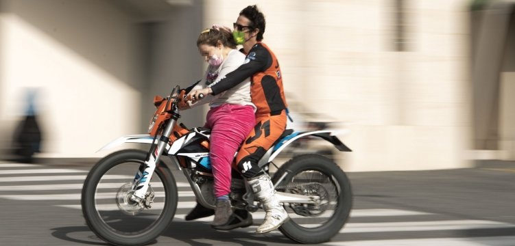 Vanni Oddera a bordo della sua moto con una ragazzina disabile