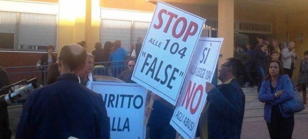 picchetto di protesta di docenti che tengono in mano cartelli con scritto "stop alle 104 false"