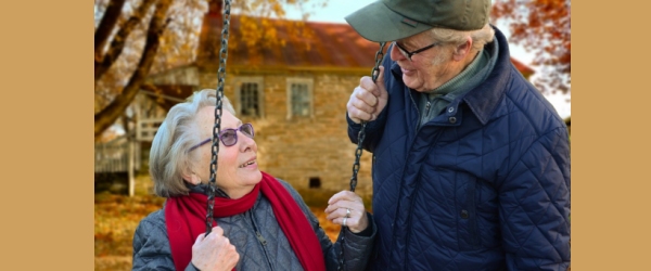 un signore anziano guarda la moglie anziana in altalena
