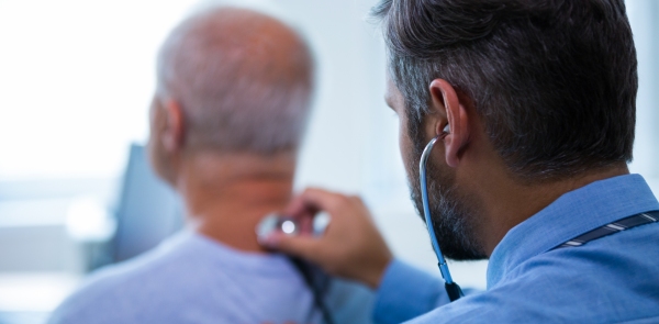 medico osculta un paziente anziano con lo stetoscopio