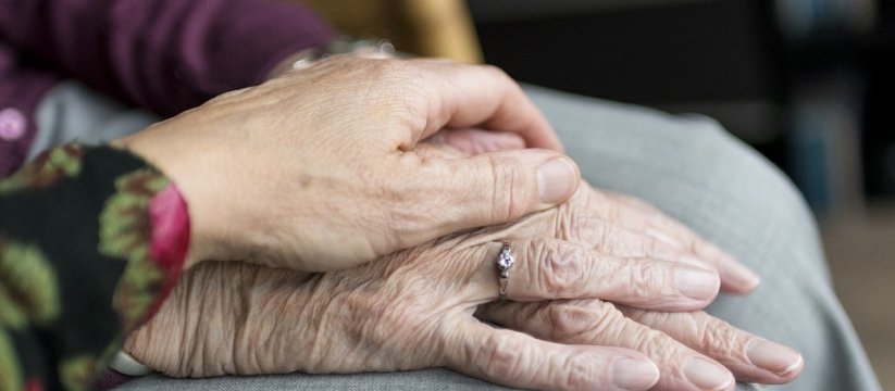 mano di donna che tiene la mano di una persona anziana