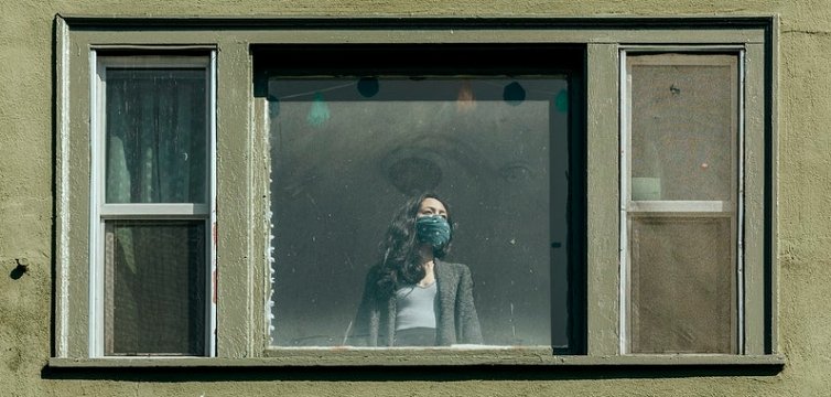 donna sola con mascherina  alla finestra