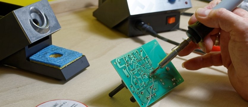 dettaglio di una mano che lavora su circuiti elettrici 