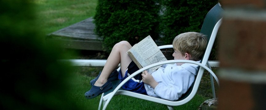 un bambino seduto su una sedia che legge