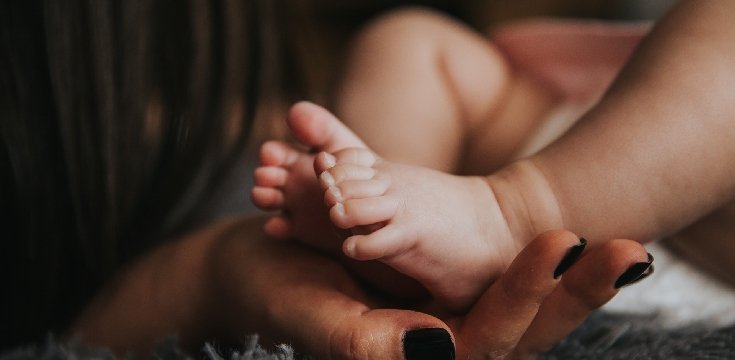 piedini di un neonato nelle mani della mamma