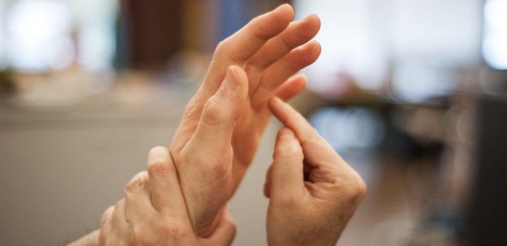 una persona segna sul palmo di un'altra un segno per comunicare
