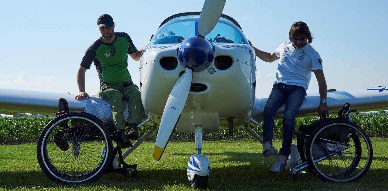 Luca Paiardi e Danilo Ragona mentre salgono su di un piccolo aereo sollevandosi dalle carrozzine