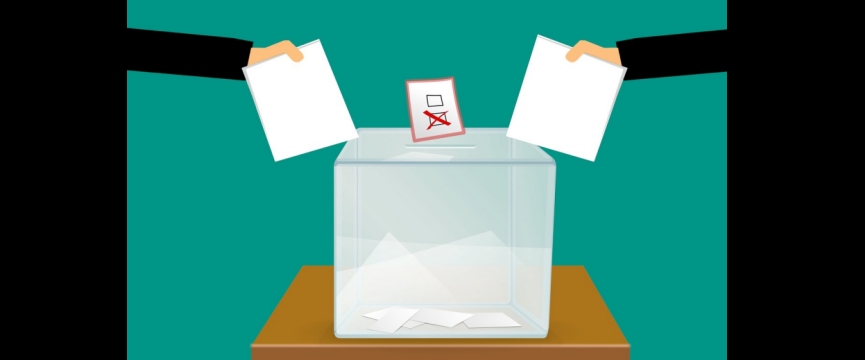 due mani che inseriscono la busta dentro un'urna elettorale