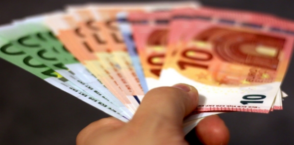 mano maschile che porge molte banconote di euro di vari tagli
