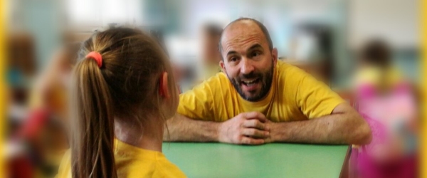 Dario Sorgato sta parlando con una bambina ed entrambi sono vestiti di giallo