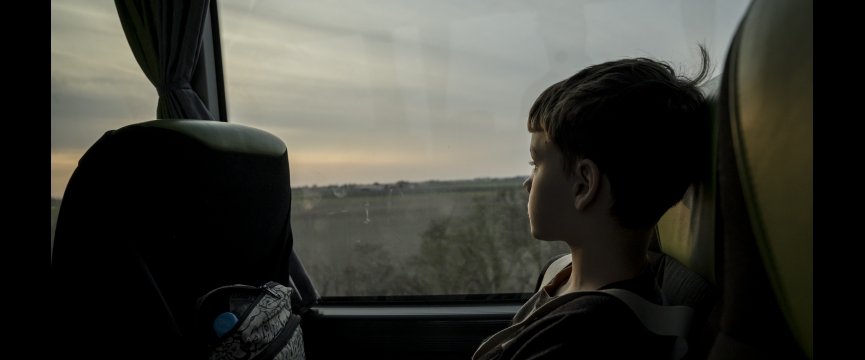 bambino in bus guarda la desolazione fuori dal finestrino