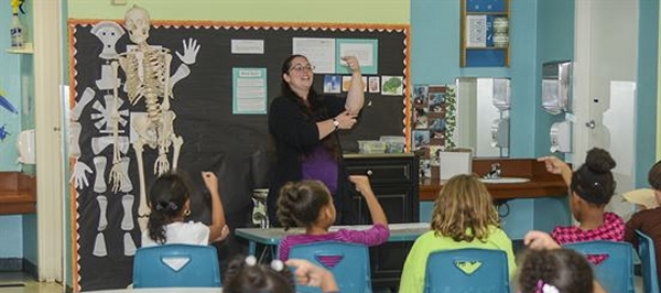 maestra insegna la lingua dei segni ad alcuni bambini in una classe