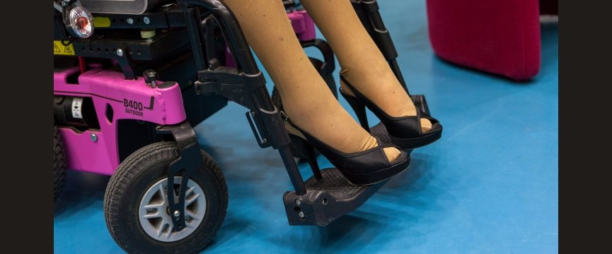 dettaglio dei piedi di una donna in carrozzina che calzano due scarpe col tacco alto