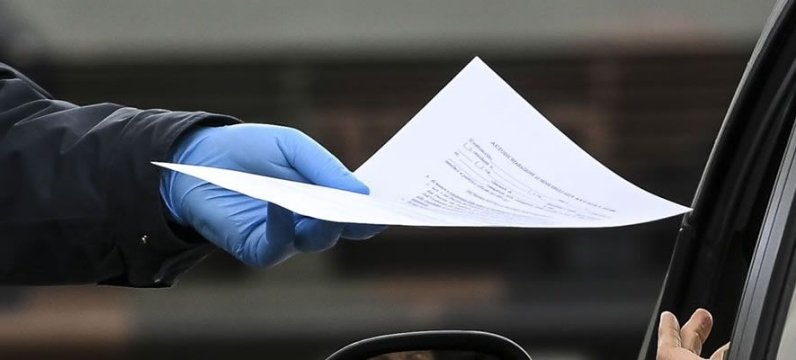 dettaglio della mano di un operatore di sicurezza che consegna un documento a una persona in auto