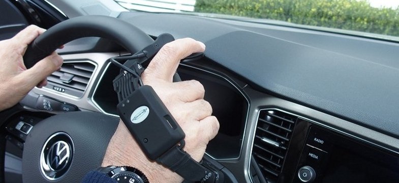 dettagli delle mani sul volante diuna persona che indossa la centralina di comandi wireless 