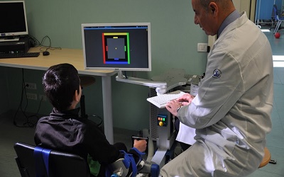 dottore e bambino che usa strumento tecnologico per neuroriabilitazione