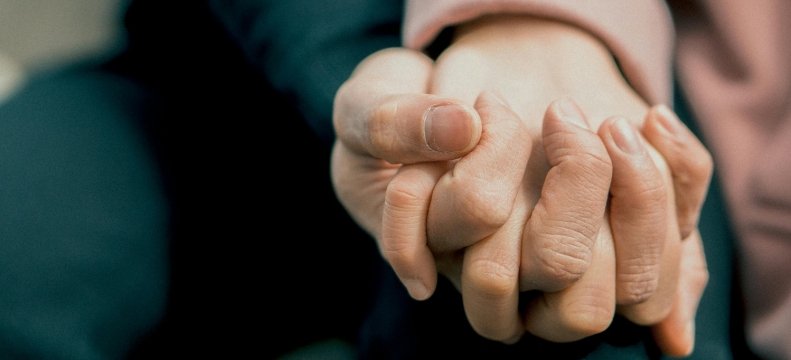 mani di due persone intrecciate tra loro