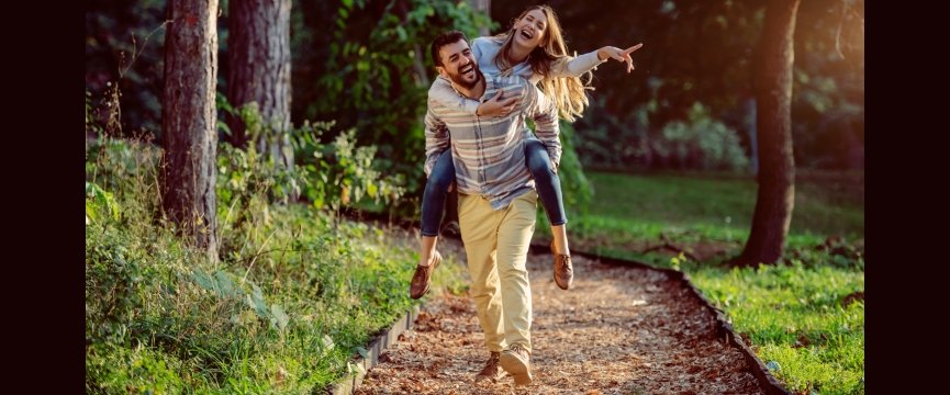 un ragazzo e una ragazza felici insieme durante una passeggiata nei pressi di un bosco 
