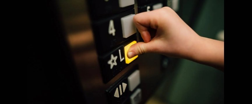dettaglio della mano di una persona mentre preme il pulsante di un ascensore