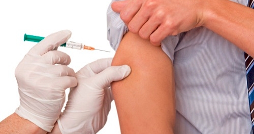 una siringa inietta un vaccino in un braccio