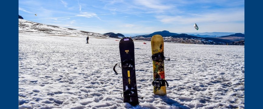 due tavole da snowboard piantate su un mucchio di neve in una pista da sci innevata 