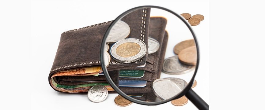lente di ingrandimento su portafoglio con banconote e monete di euro