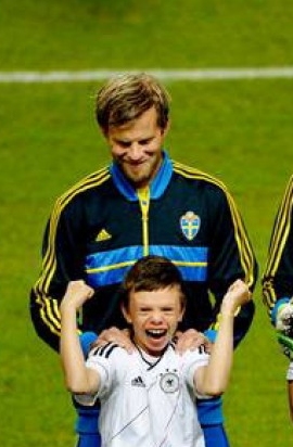 Uh calciatore famoso abbraccia un bambino autistico felice