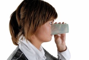 donna beve senza inclinare la testa da un bicchiere con una apertura all'altezza del naso