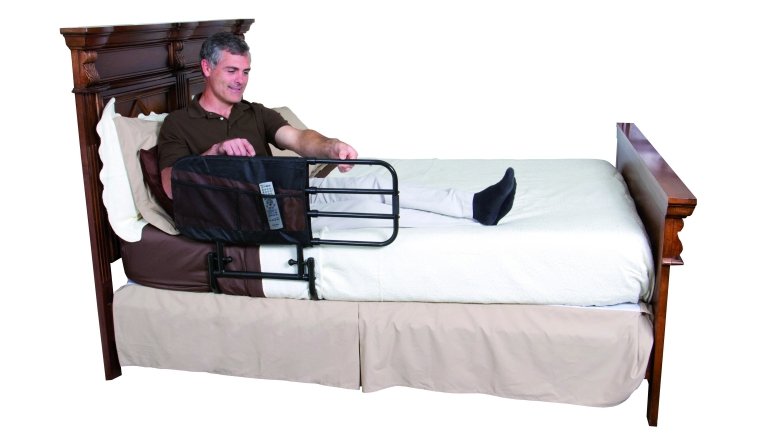 utente steso sul letto al quale è applicata la sponda anticaduta