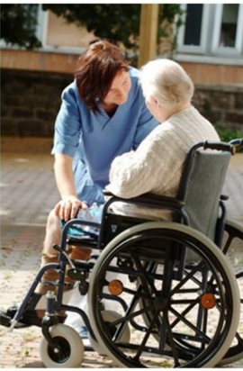 donna parla con anziana in carrozzina 