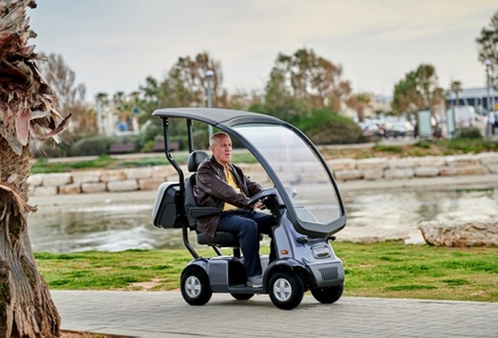 uomo sta guidando uno scooter elettrico con tettuccio