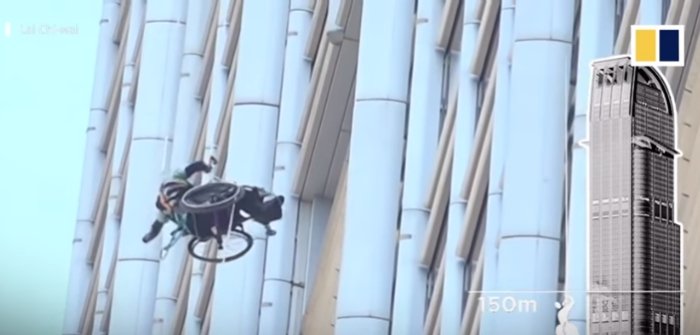 il climber disabile Lai Chi wai appeno ad una corda mentre scala il grattacielo