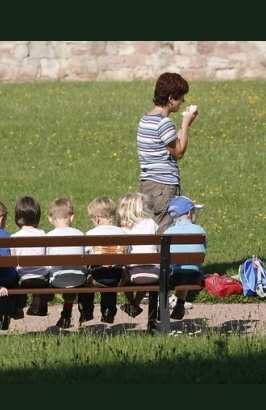 maestra e bambini seduti su una panchina 