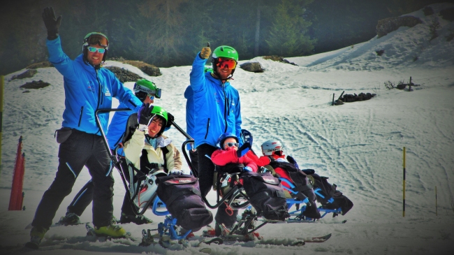 maestri di sci con persone disabili in pista